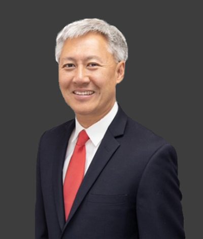 Christopher Kim in a suit and tie smiling for a professional photograph