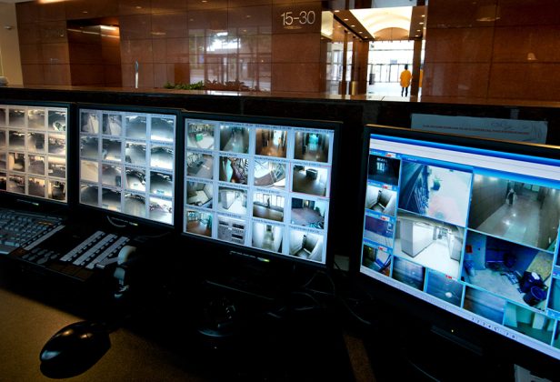 several monitors are lined up in a security monitoring room