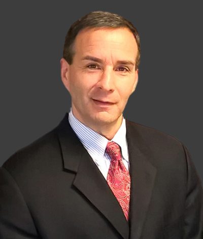 Alan Katz in a suit and tie smiling for a headshot