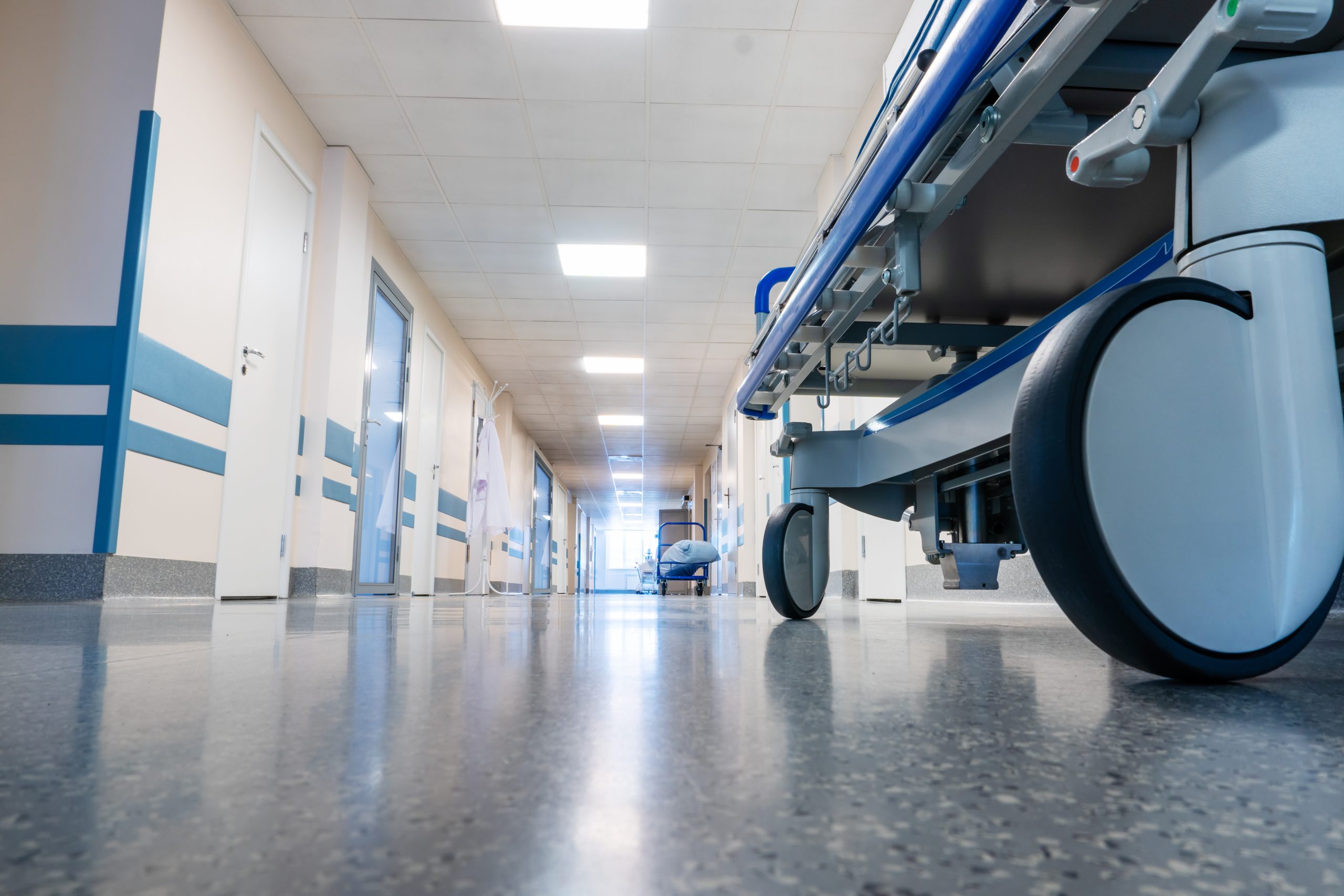 a hospital hallway with a stretcher being rolled down it