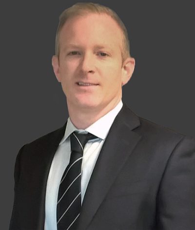 Cathal Walsh in a suit and tie is smiling at the camera for a professional headshot