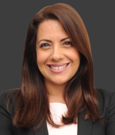 Tania Benedit is smiling and wearing a black jacket and white shirt for a headshot