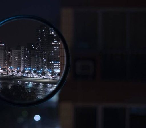 a city at night is reflected in a magnifying glass