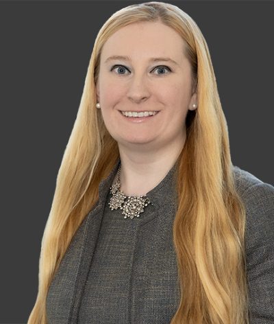 Angela Osborne in a gray suit smiling for a professional photograph