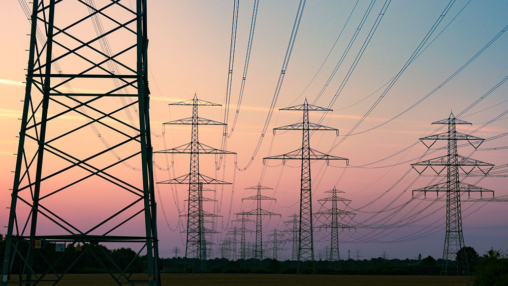 a row of power lines with a pink sky in the background