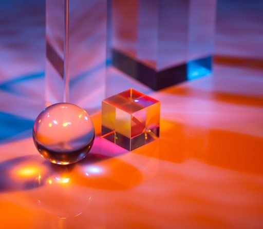 a glass ball is sitting next to a glass cube on a table