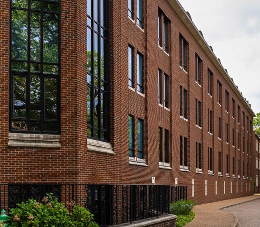 a large brick building with windows on a college campus