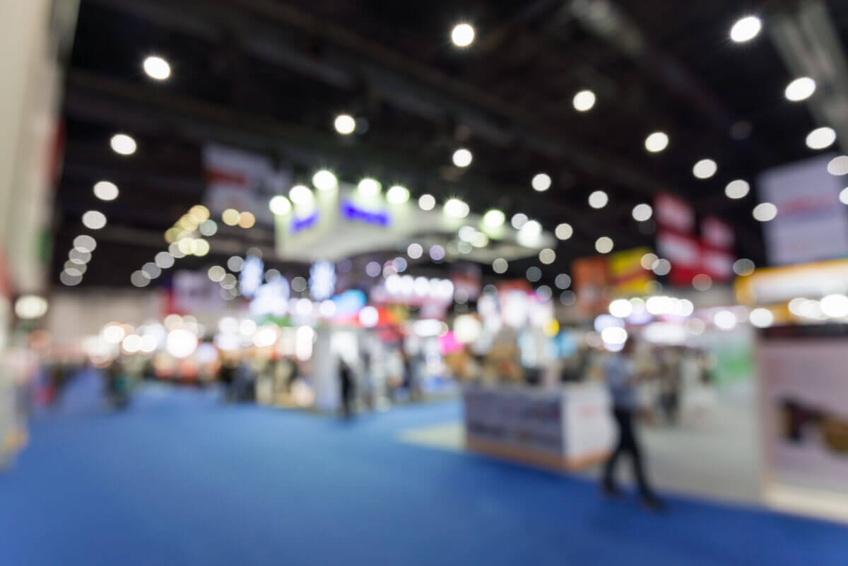a blurry picture of a convention with a blue floor