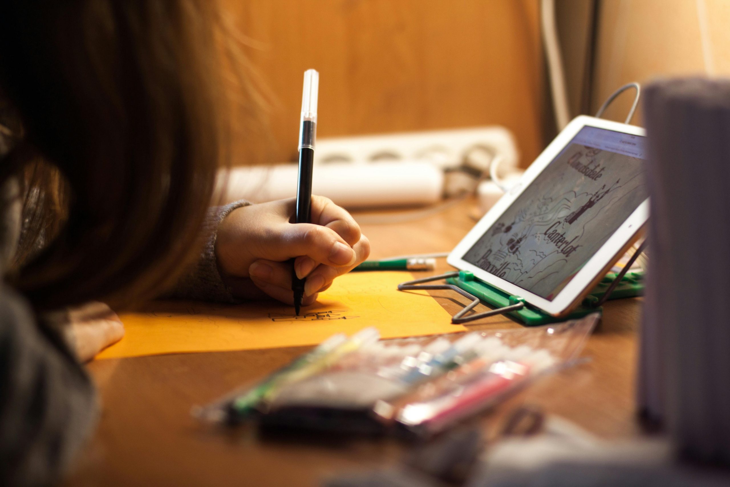 a child drawing a picture from a tablet