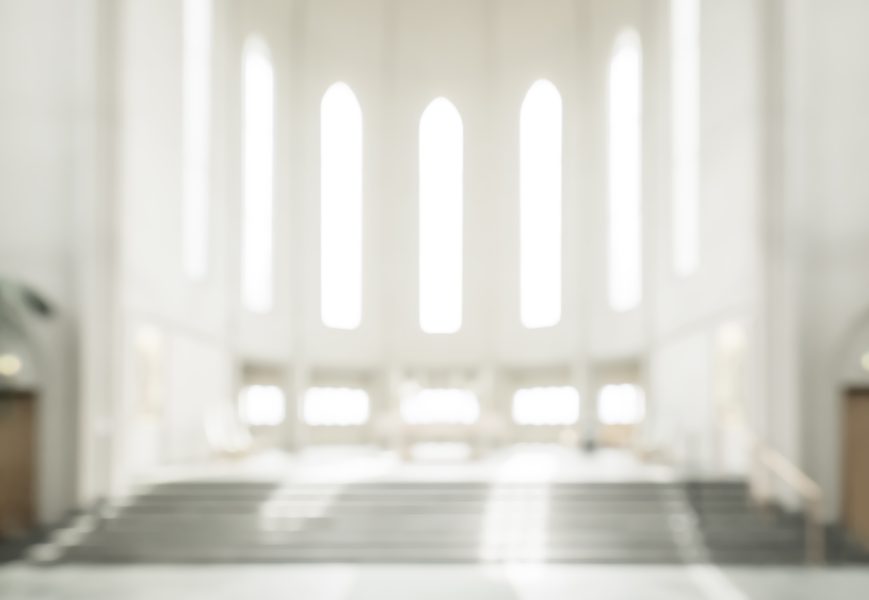 a blurry picture of a white church with stairs and windows
