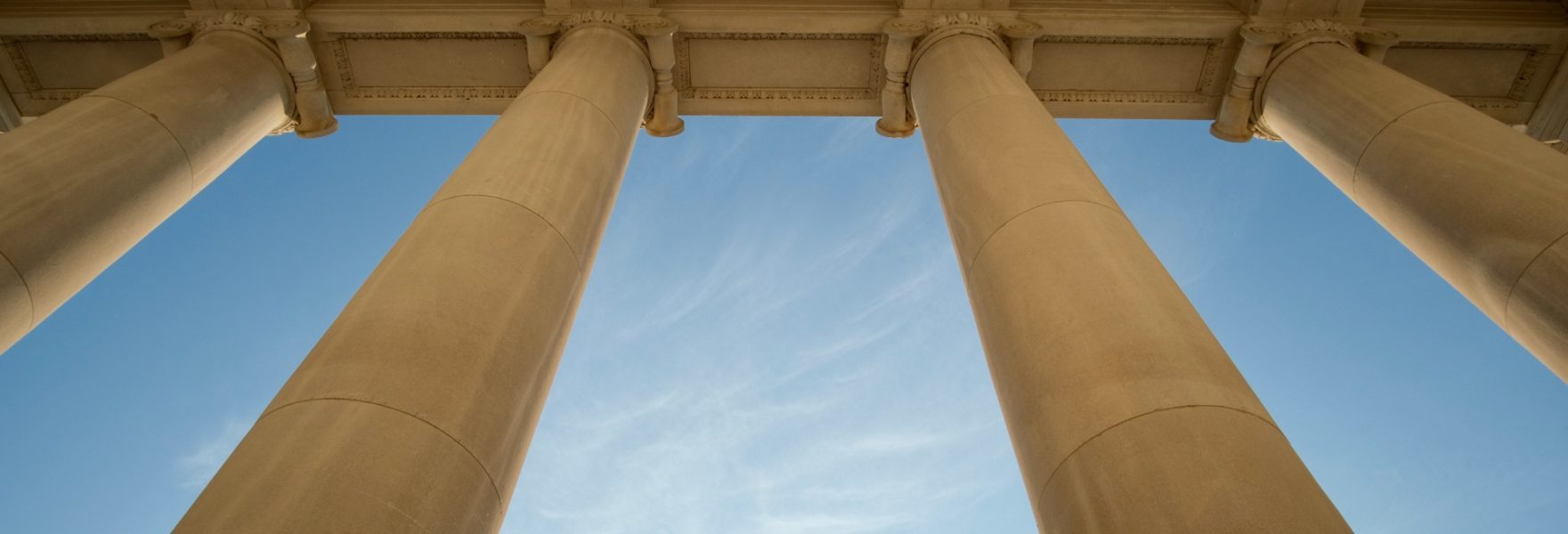 Towering government columns with a blue sky background